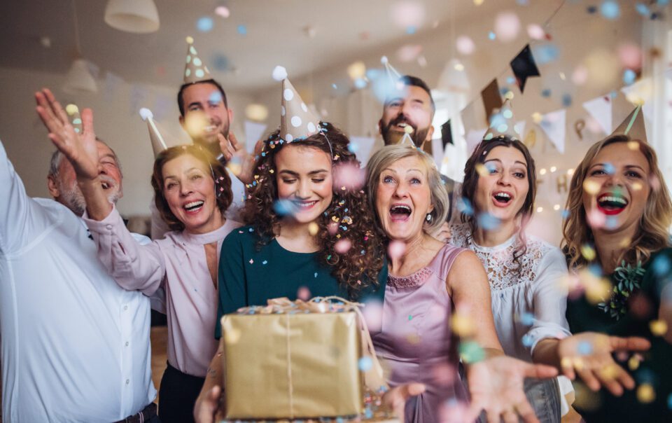 A portrait of multigeneration family with presents on a indoor birthday party.